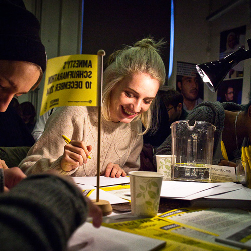 Image of people writing letters at Amnesty International Netherlands